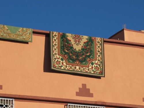 A rug hanging over the edge of a building in Tinghir